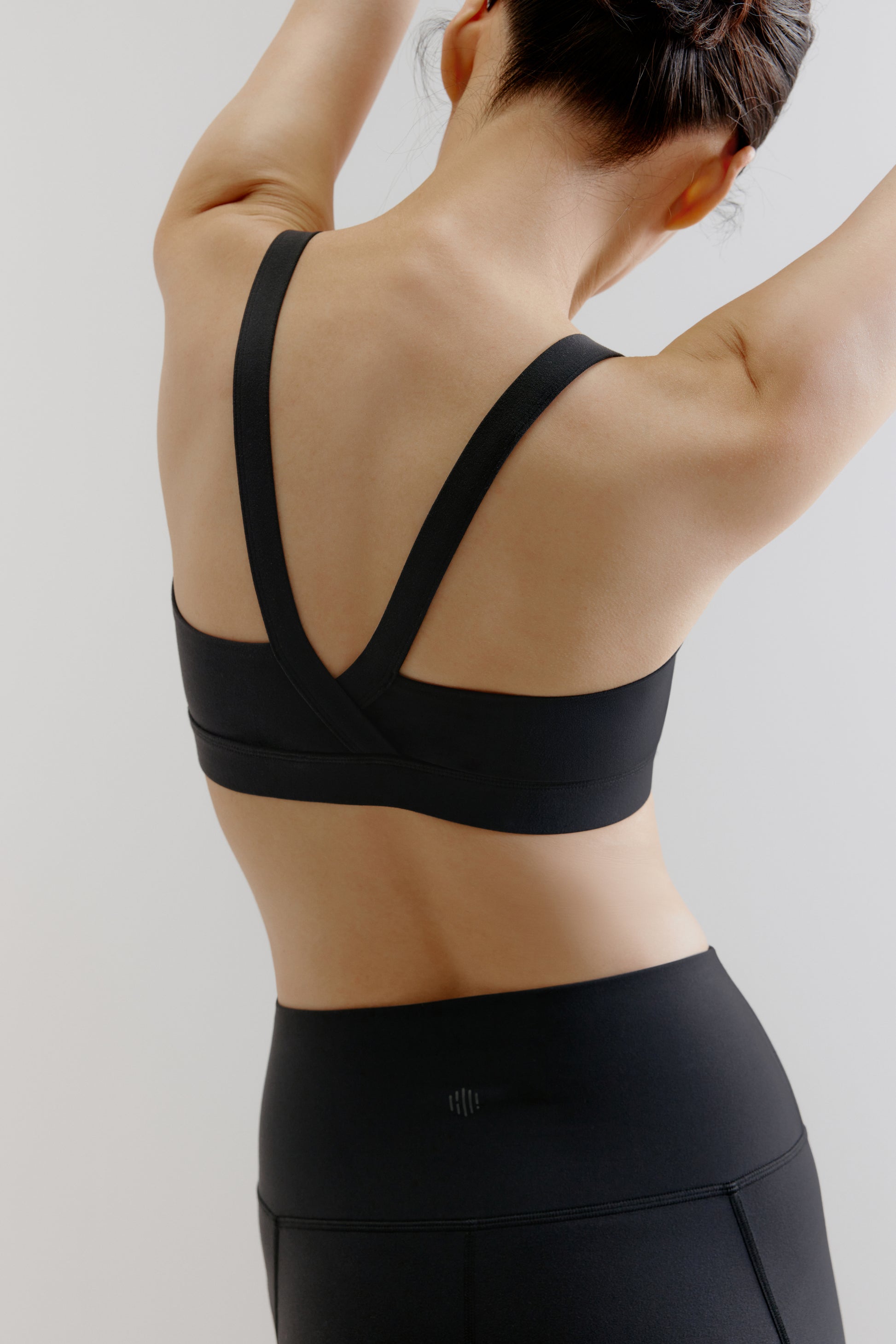 back of woman in black sports bra