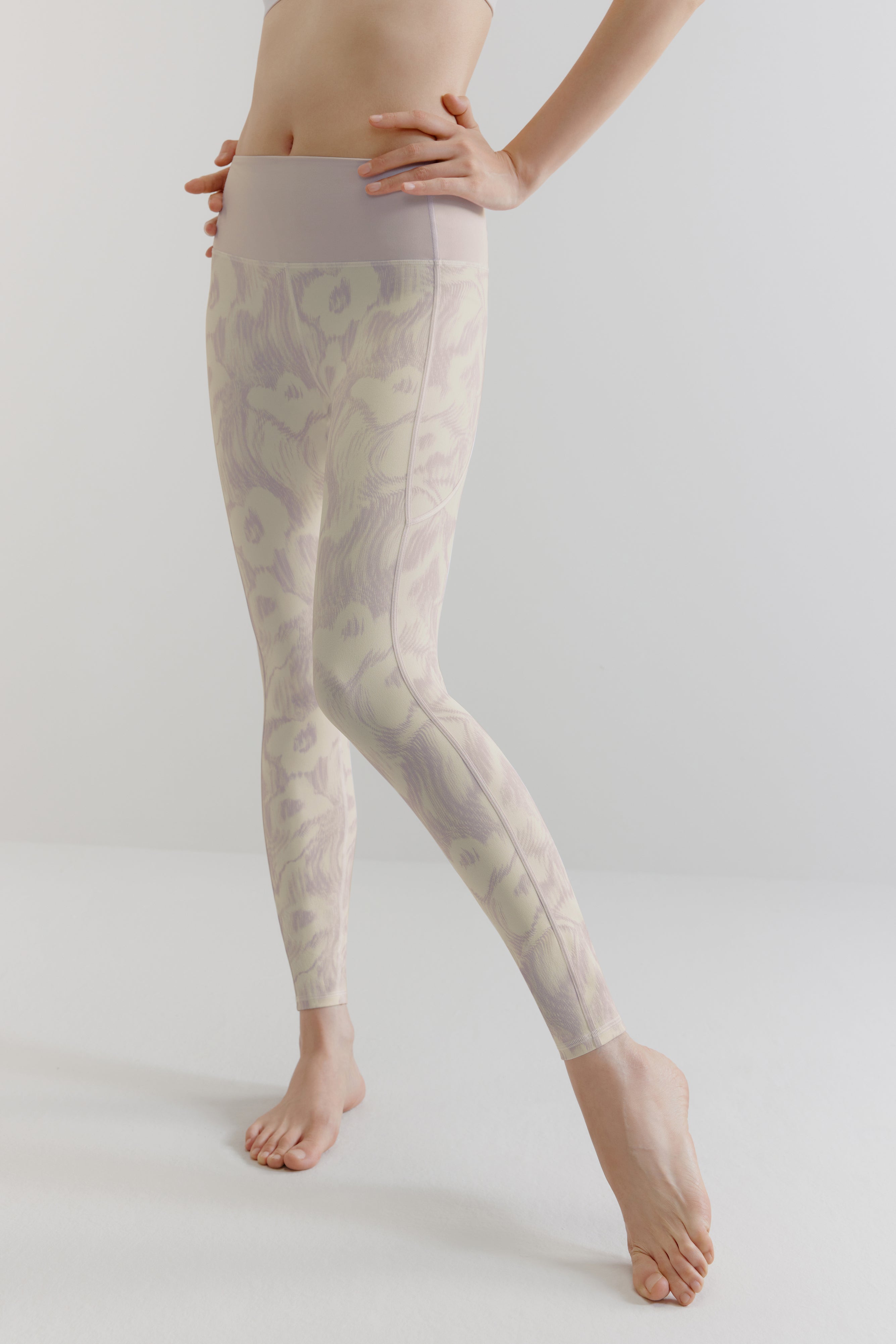 a woman wears a purple and white patterned leggings.