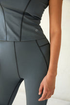 detail shot of a woman wearing a dark grey t shirt and dark grey legging