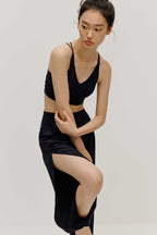 a woman wearing a black bra and black tapered joggers with side slits.