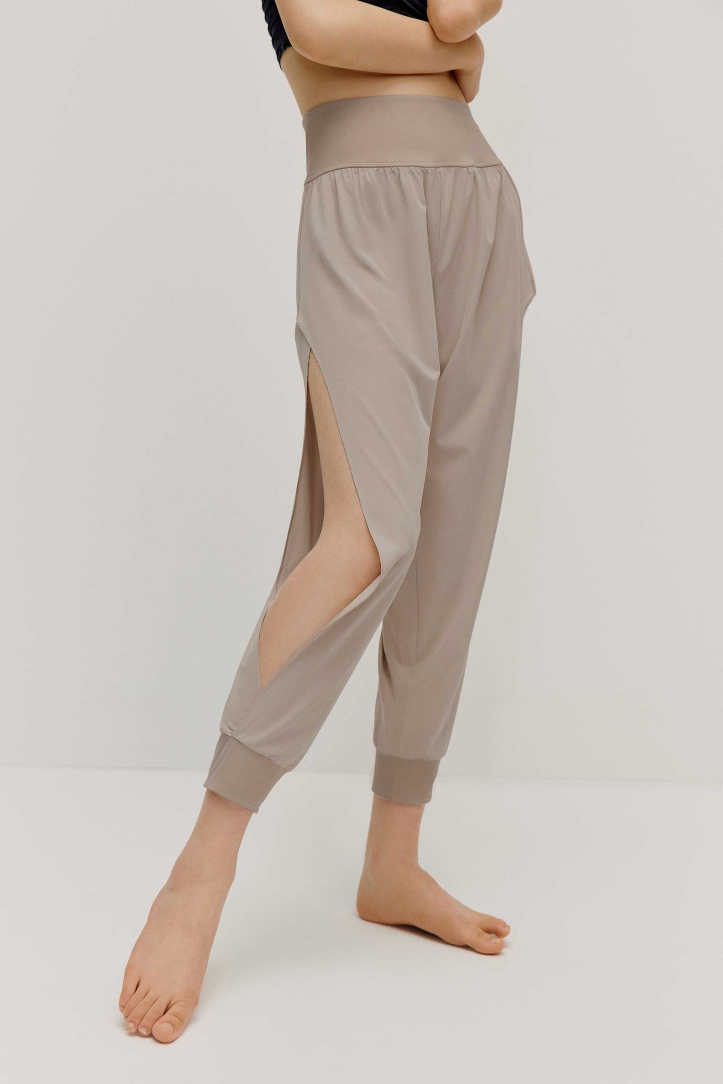  a woman wearing a pair of light grey tapered joggers with side slits