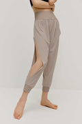  a woman wearing a pair of light grey tapered joggers with side slits
