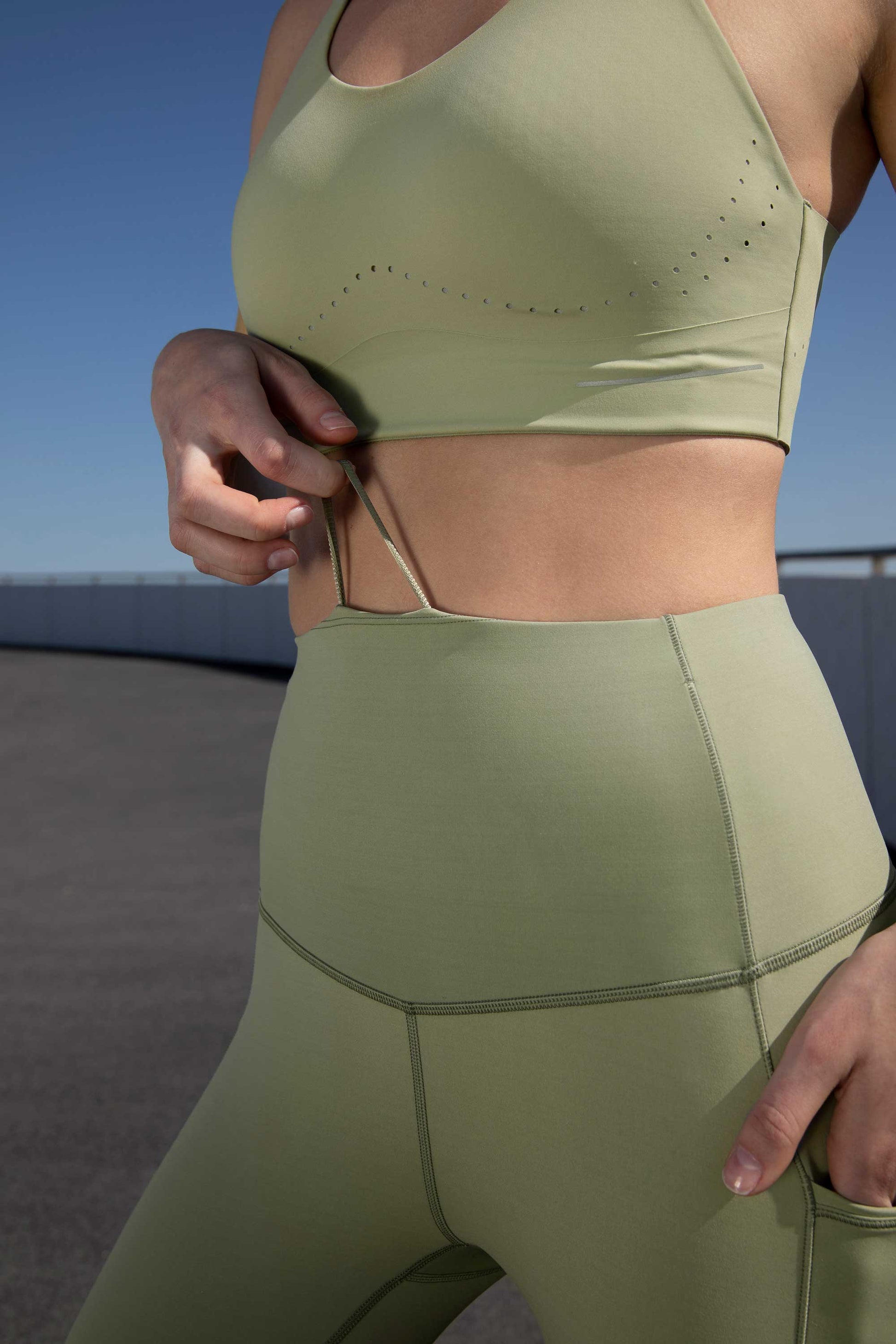 close up of woman in green sports bra and leggings