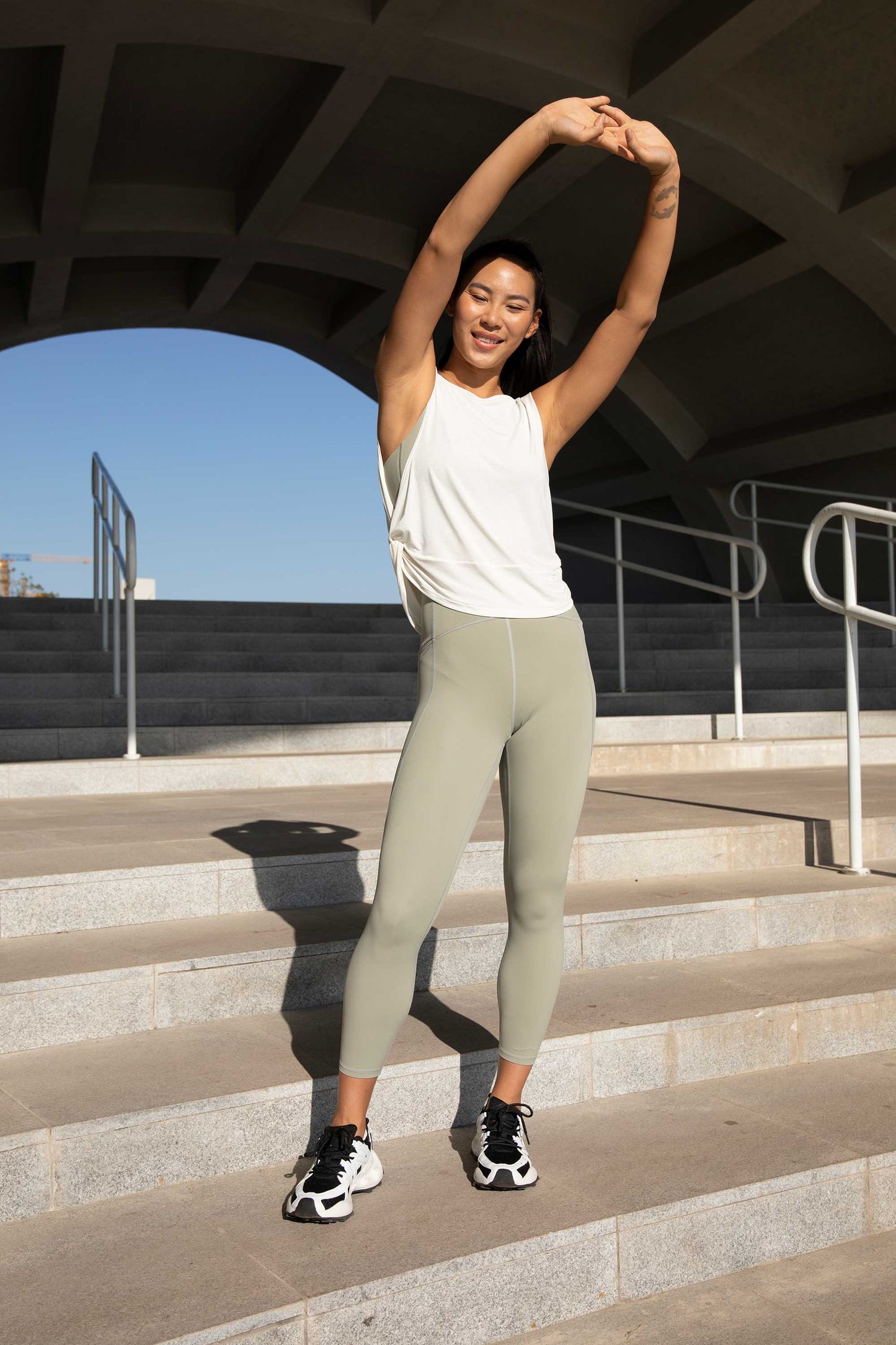 woman with white tank top and green leggings