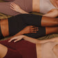 3 women lying, wearing bra and biker shorts in mutliple colors.