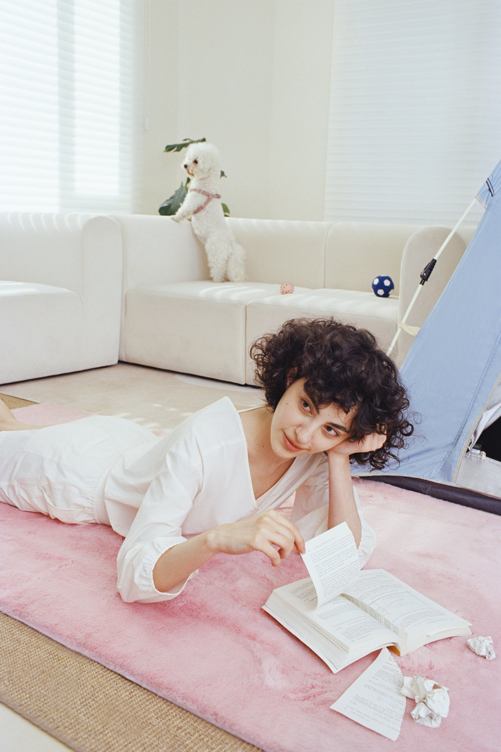 Woman wearing white sleeved top on the rug.