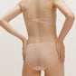 back of a woman wearing a nude Crossover Low Waist Brief and nude bra