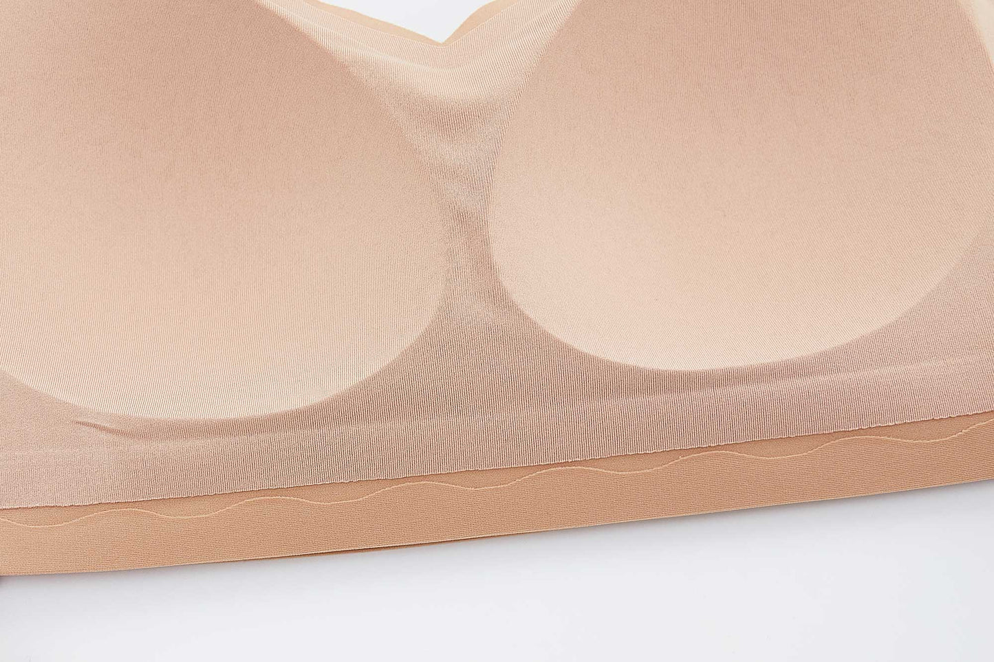 the inside of a nude color bra showing sewed in pads