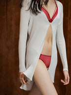 Woman wearing red lace bra with matching brief with cream cardigan.