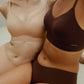 Woman wearing tan-colored bra and brief set and woman wearing brown bra and brief set
