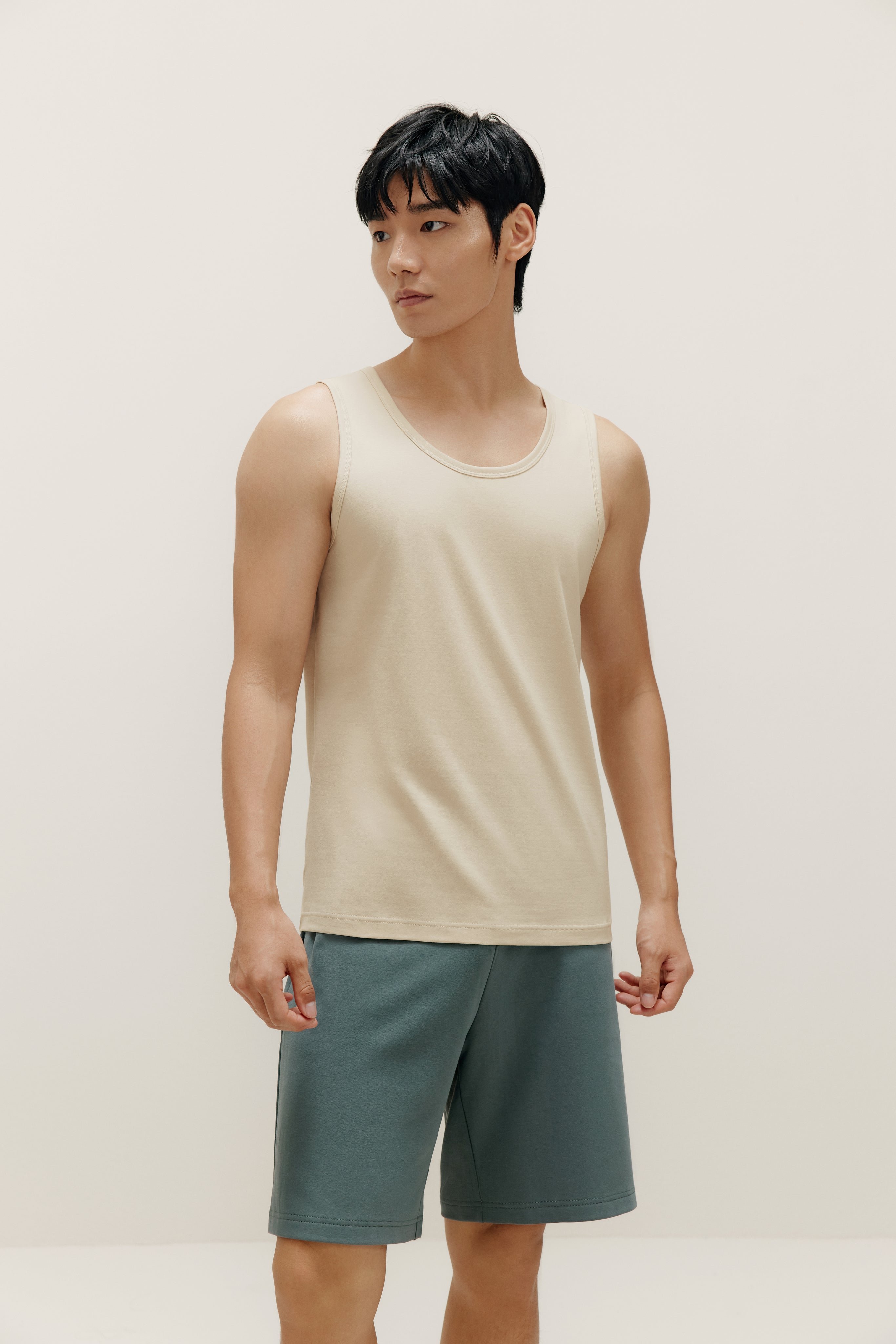 front view of man wearing white tank top and blue shorts