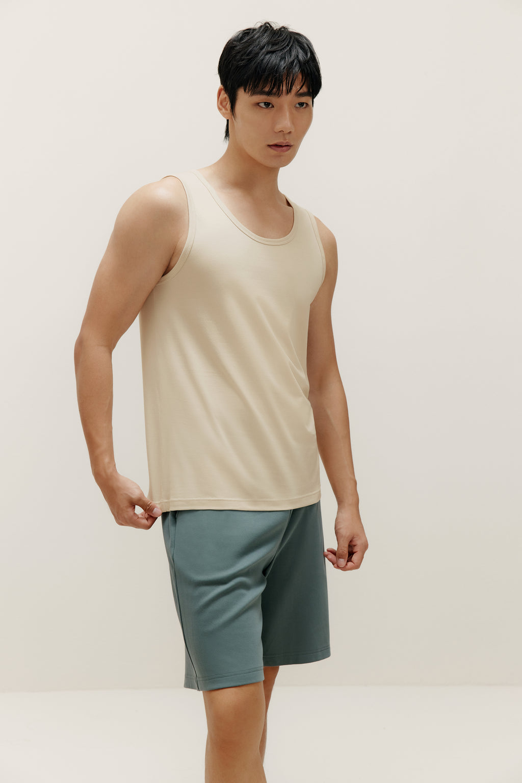 front view of man wearing white tank top and blue shorts