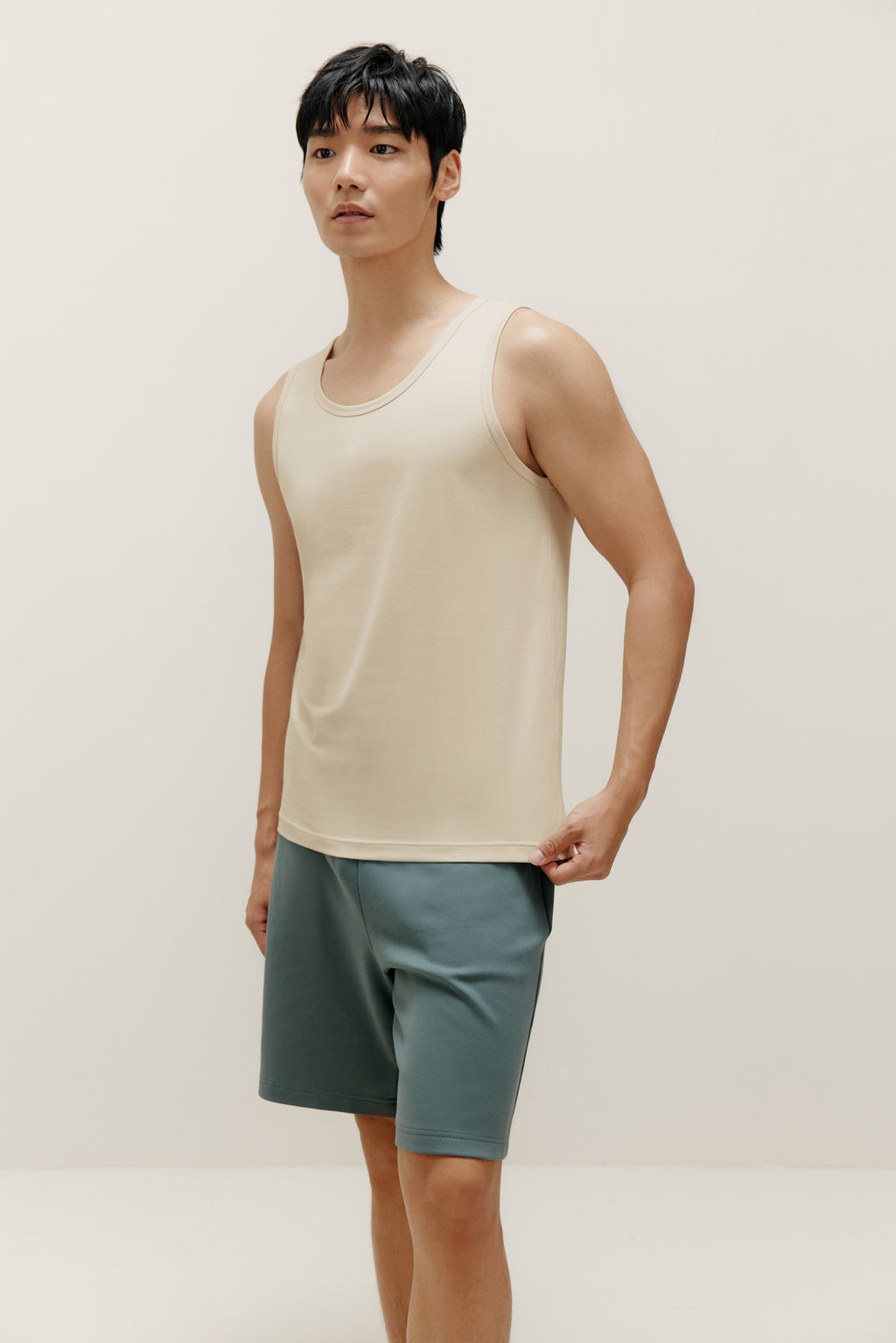  man wearing white tank top and blue shorts