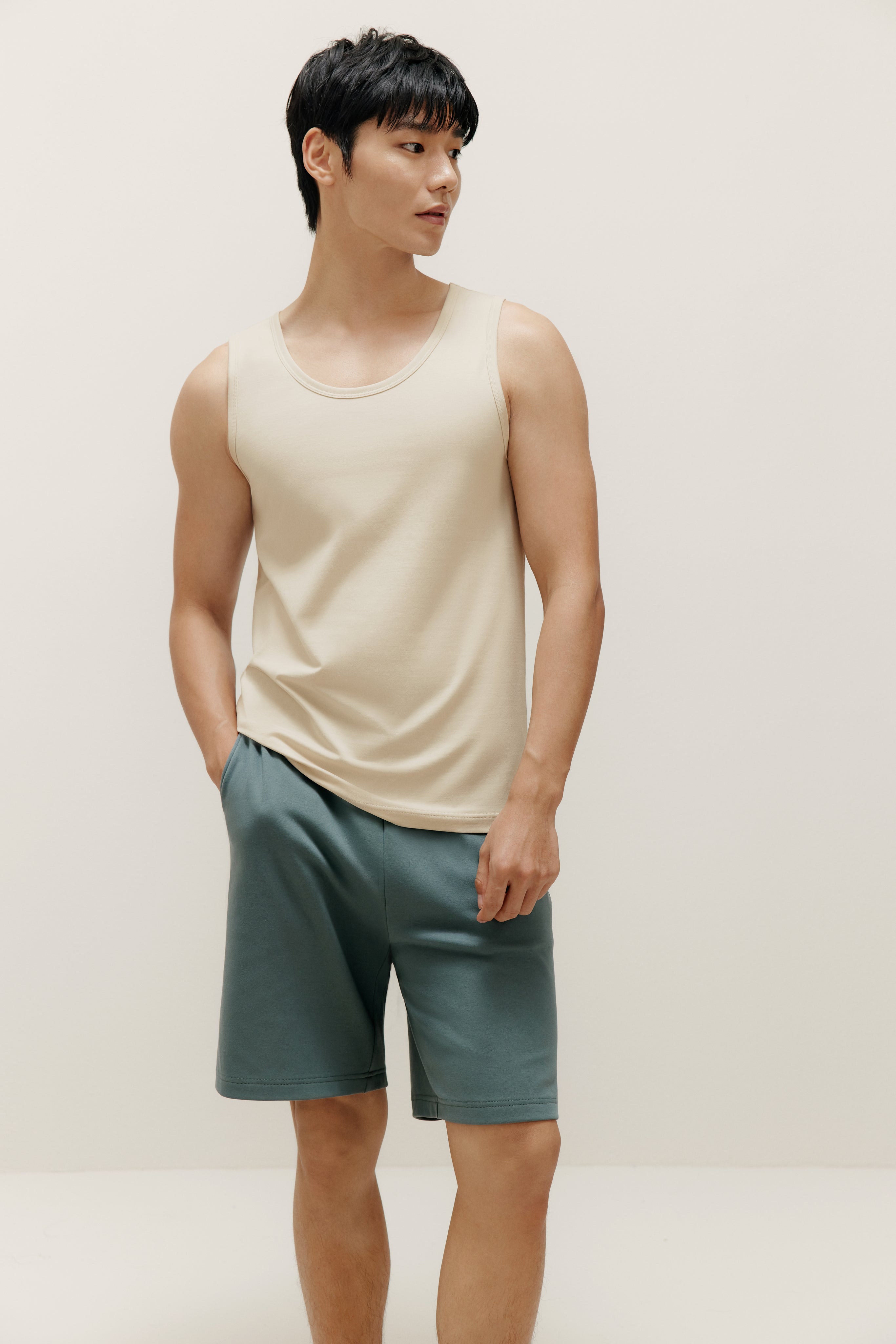 man wearing white tank top and blue shorts