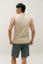 backside of man wearing white tank top and blue shorts