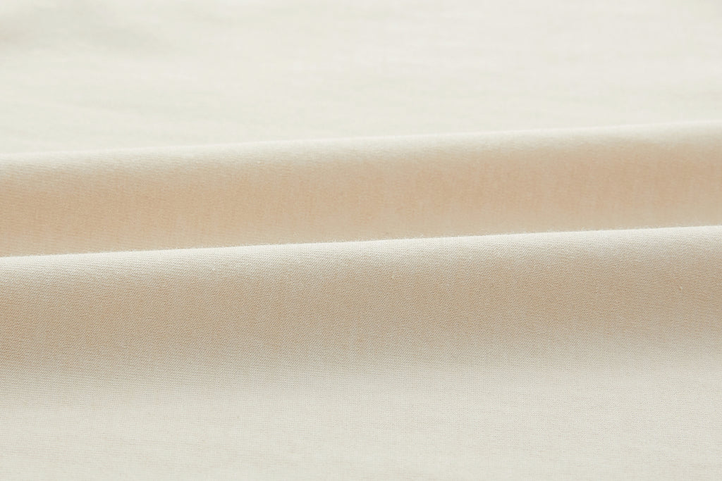 Closeup of beige fabric. White color.