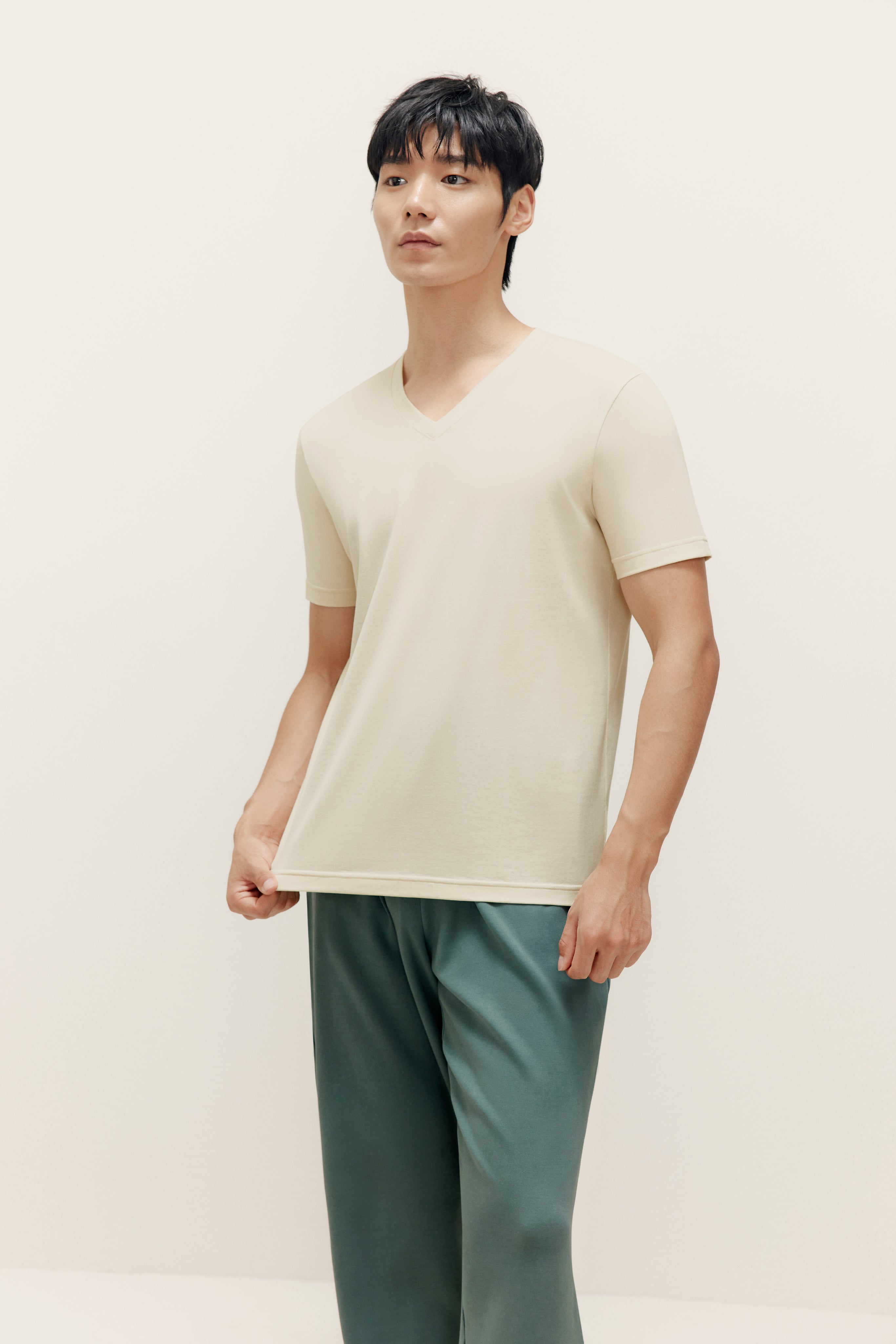 Man wearing beige V-neck T-shirt and teal lounge pants