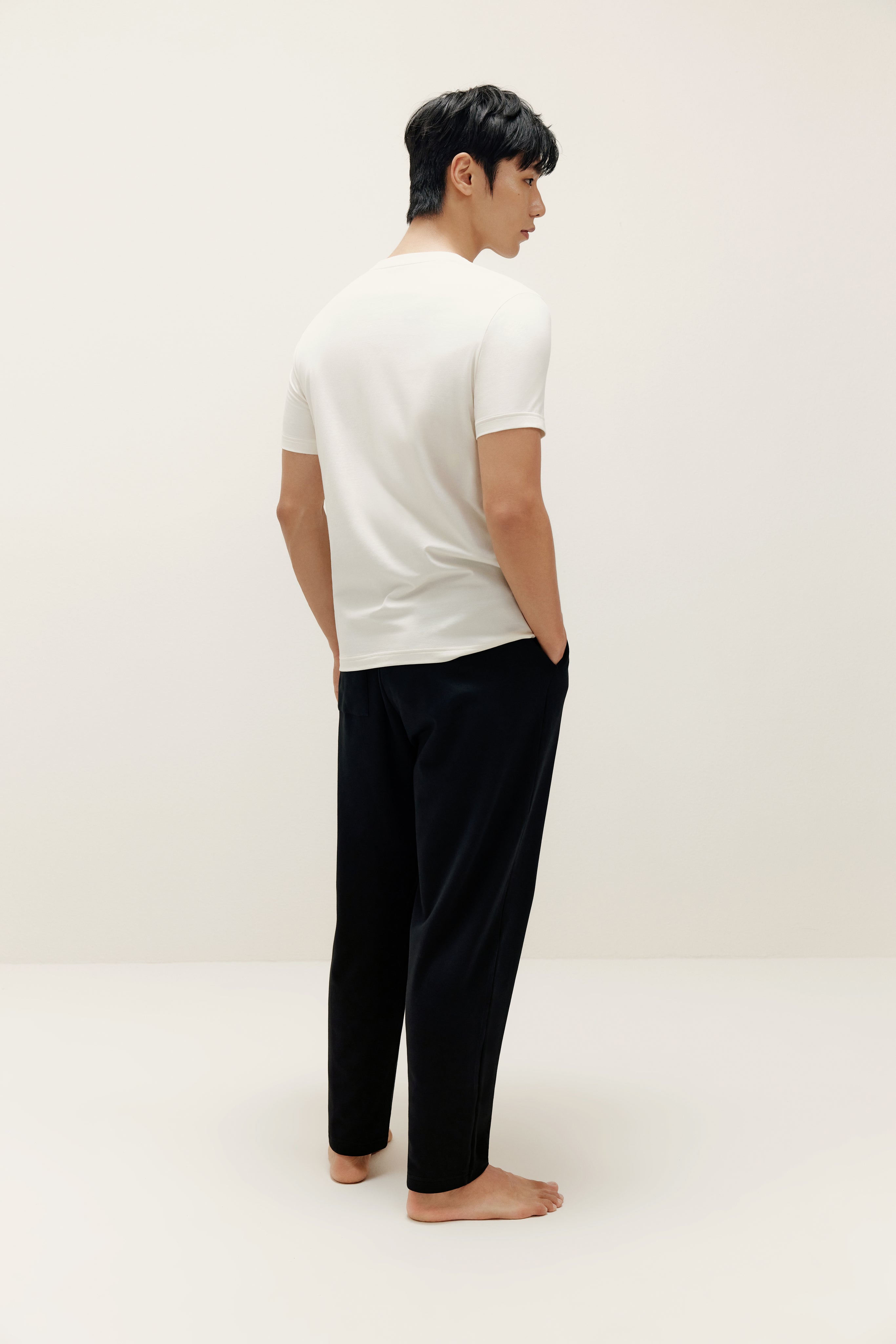 Back of man wearing white T-shirt and black lounge pants