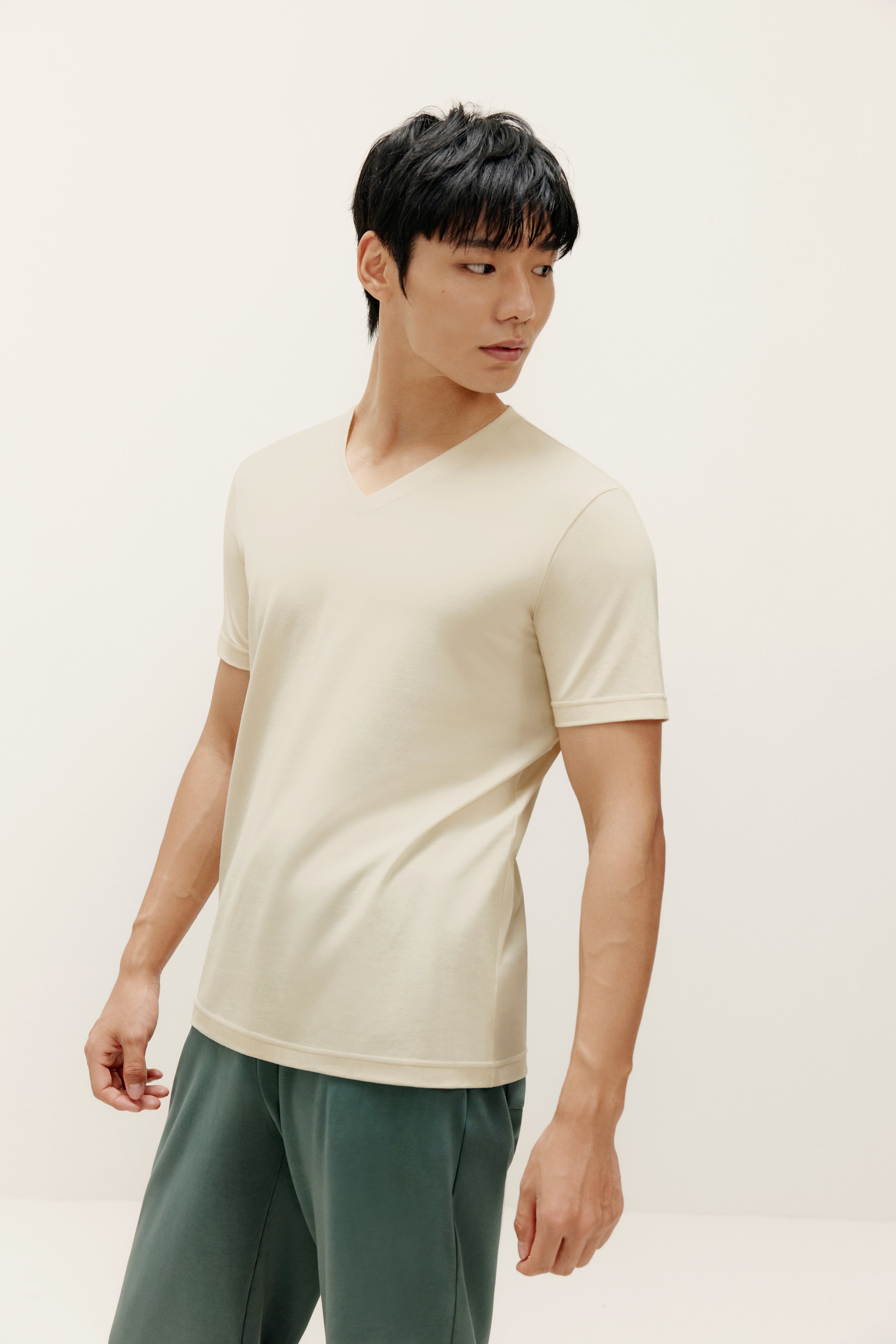 Man wearing beige V-neck T-shirt and teal lounge pants