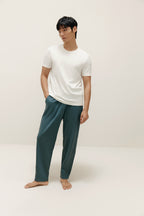 Man wearing white T-shirt and teal lounge pants. White color.