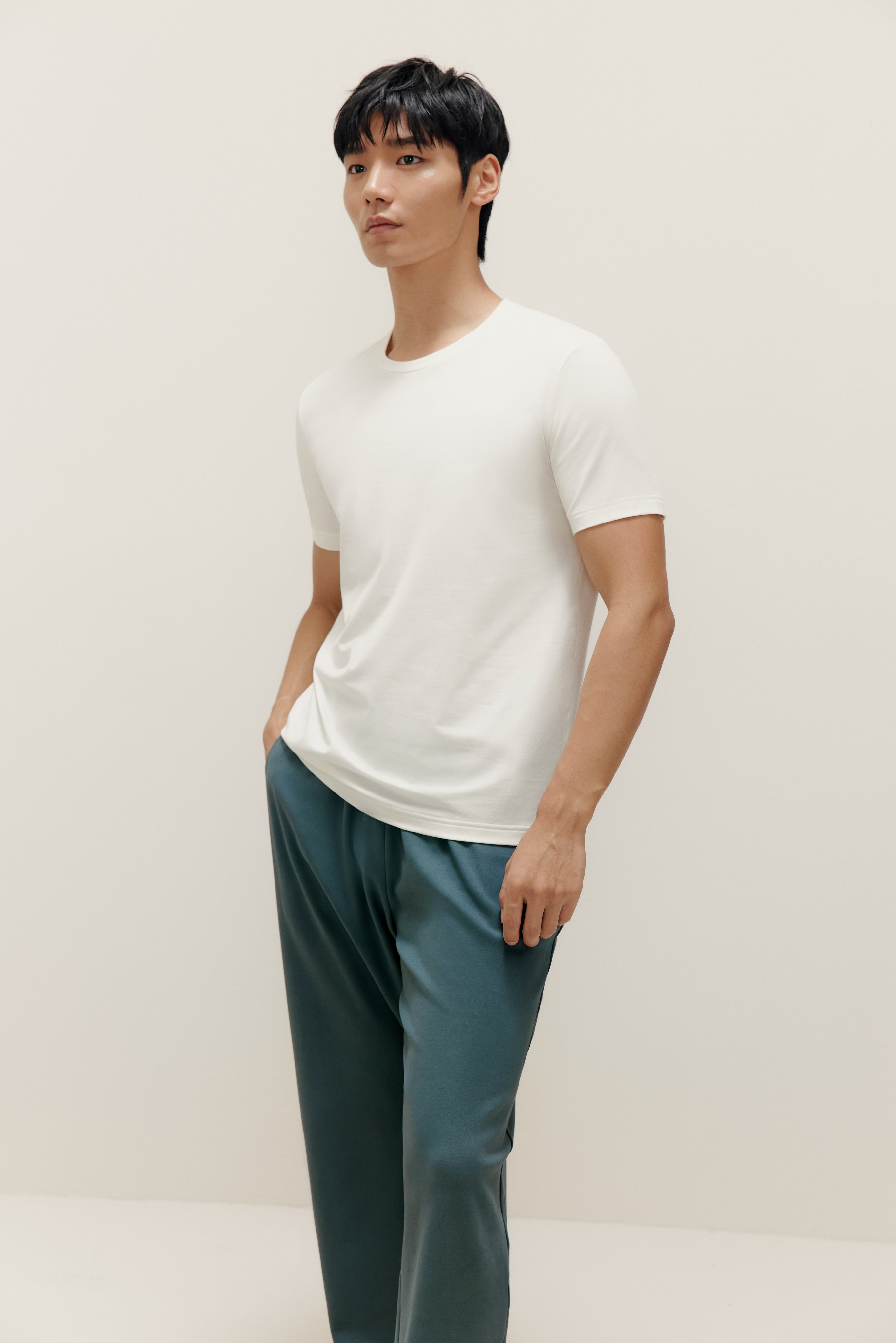 Man wearing white T-shirt and teal lounge pants. White color.