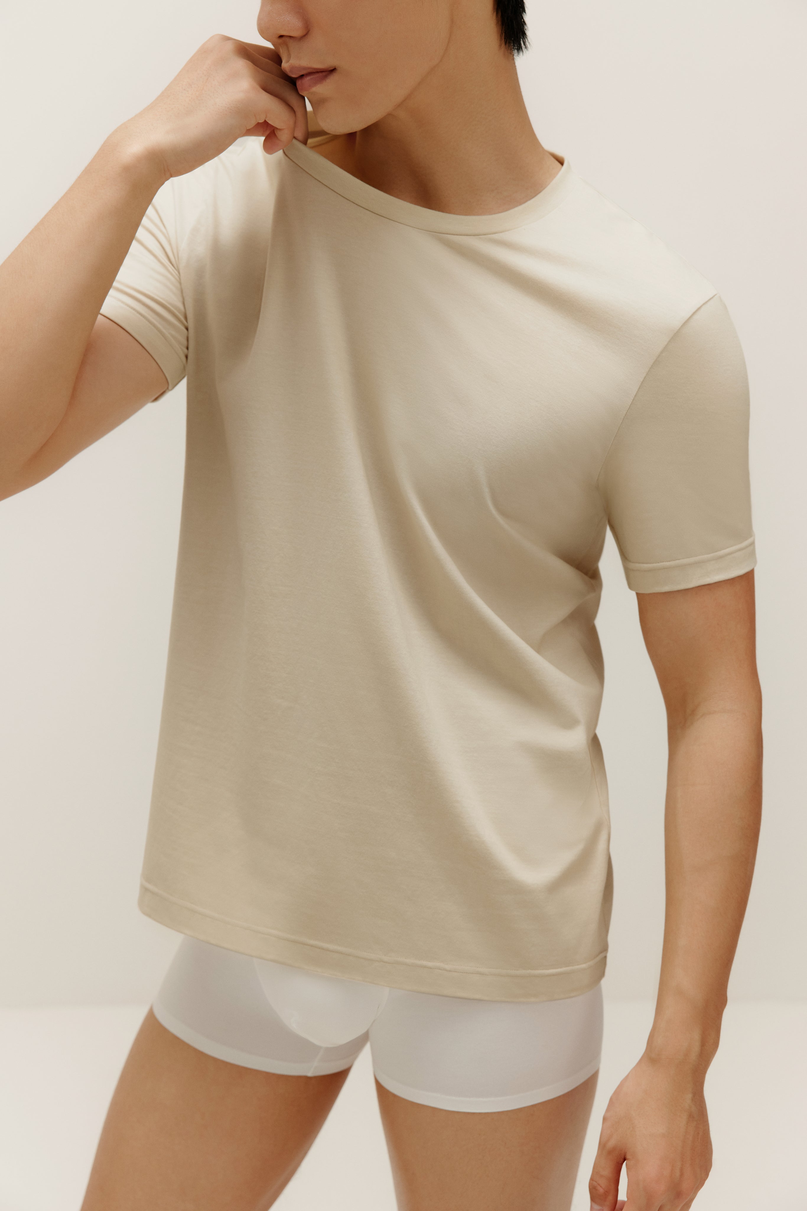 Man wearing beige T-shirt and white boxer briefs