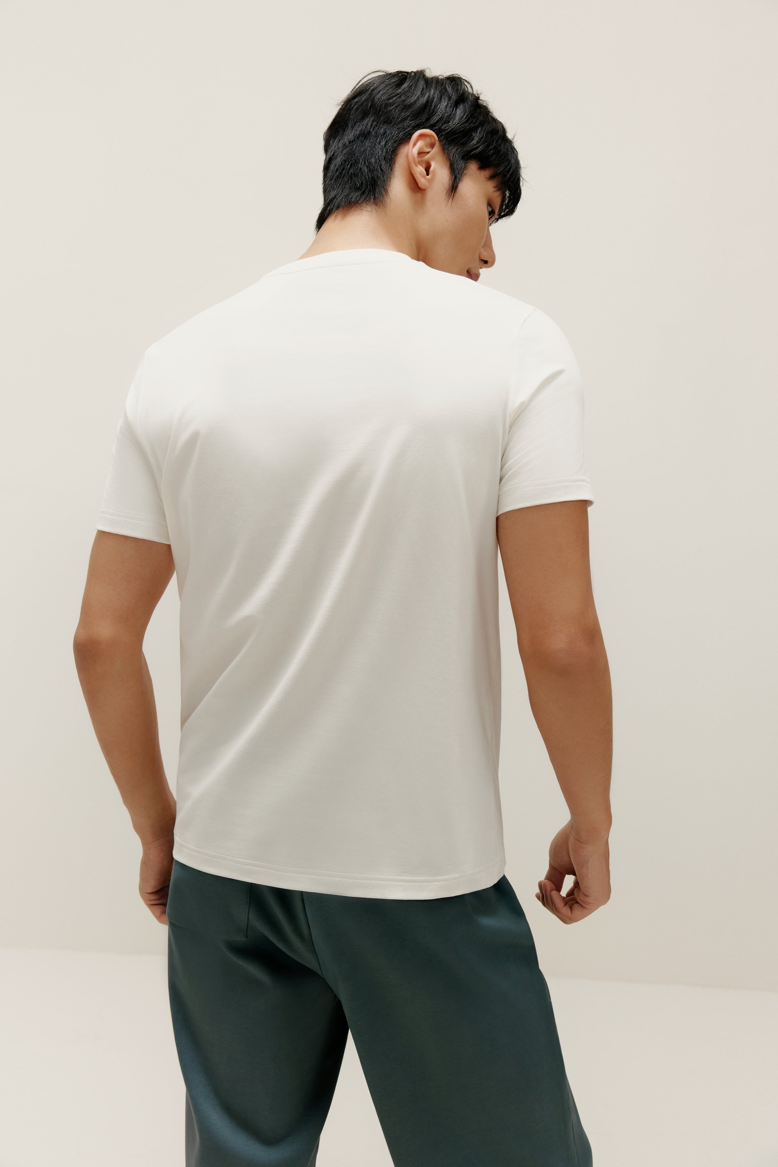 Back view of man wearing white T-shirt and blue pants