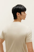Man wearing beige T-shirt. Almond color.