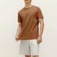 a man wearing brown t shirt and white shorts