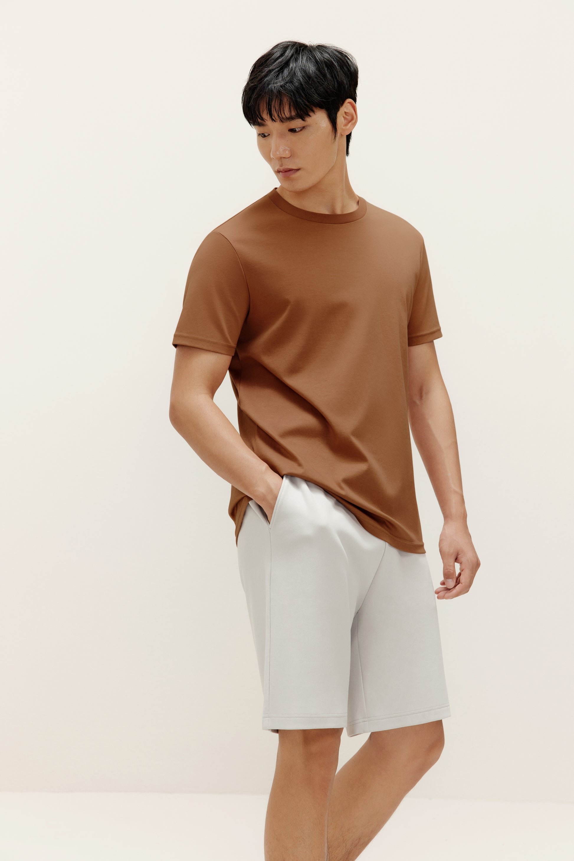 a man wearing brown t shirt and white shorts