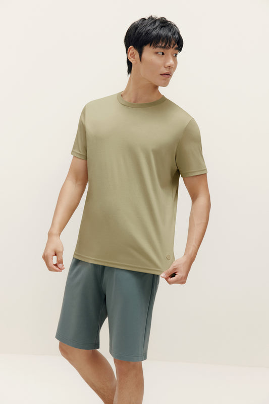 a man wearing green t shirt and dark green shorts