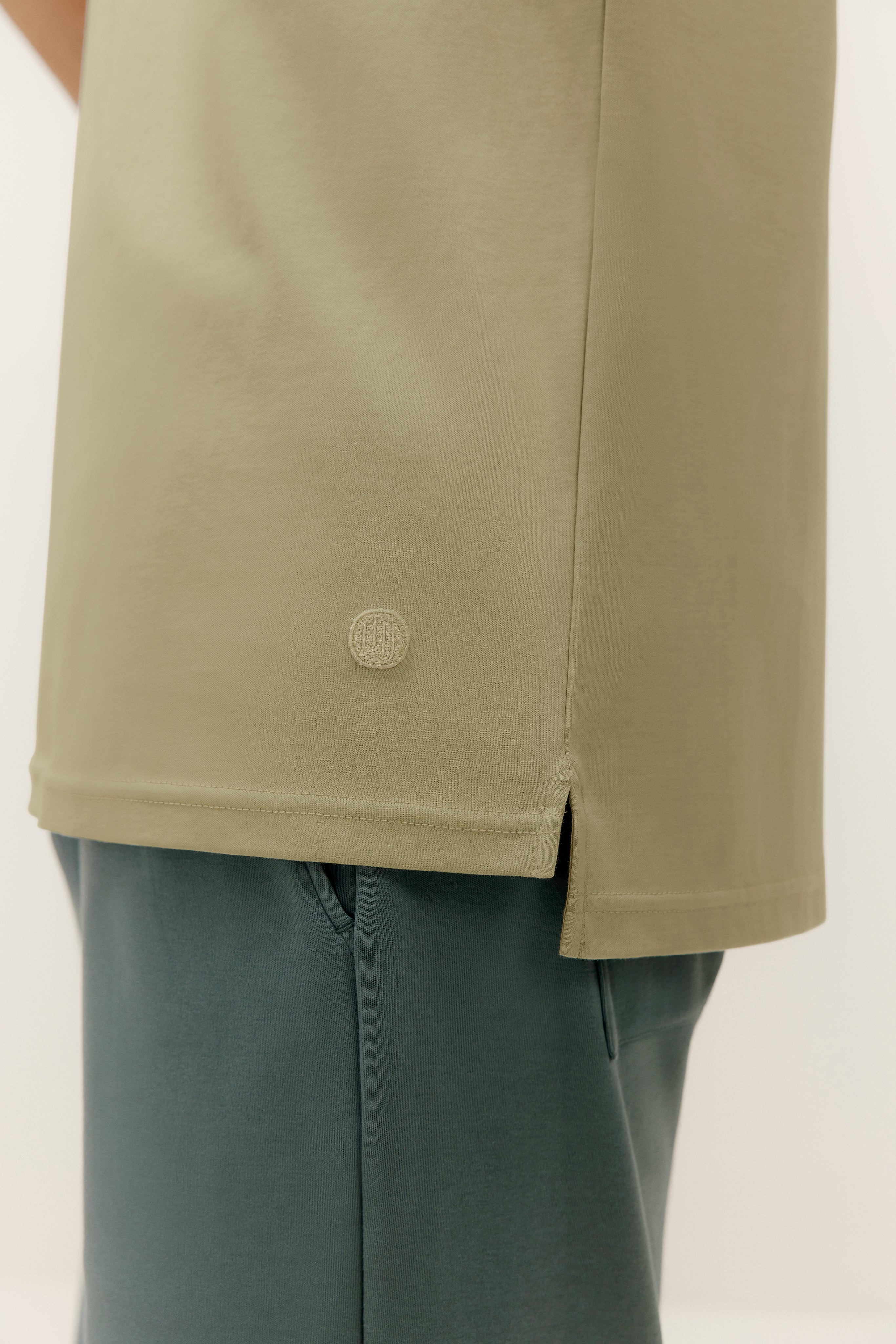 green t shirt side detail with logo