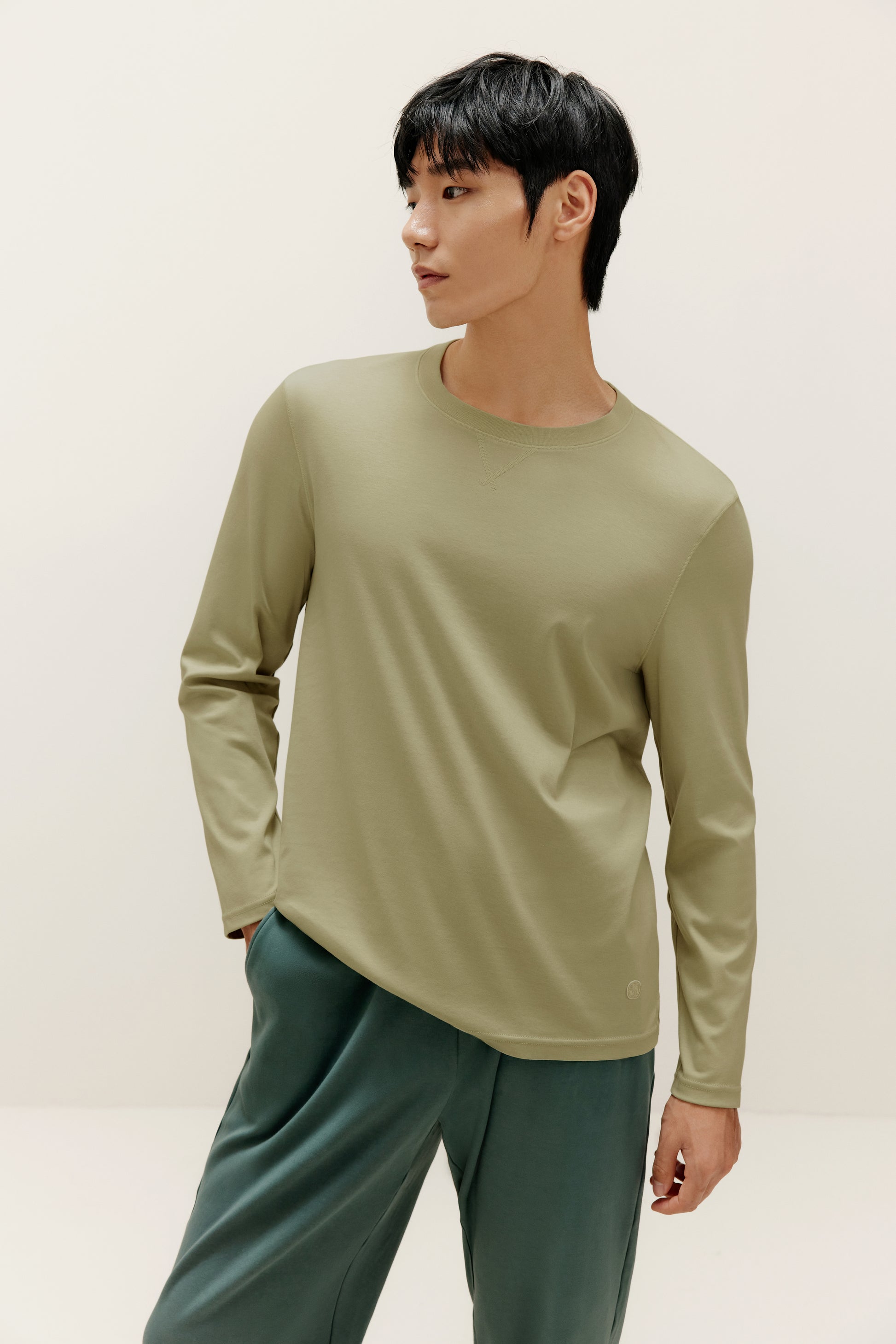 man wearing a green long sleeve and dark green pants