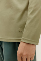 detail of the green long sleeved top with logo