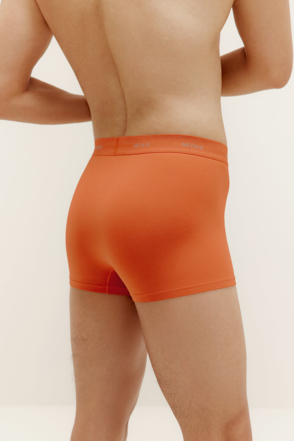 A man wearing orange brief. Sienna color.