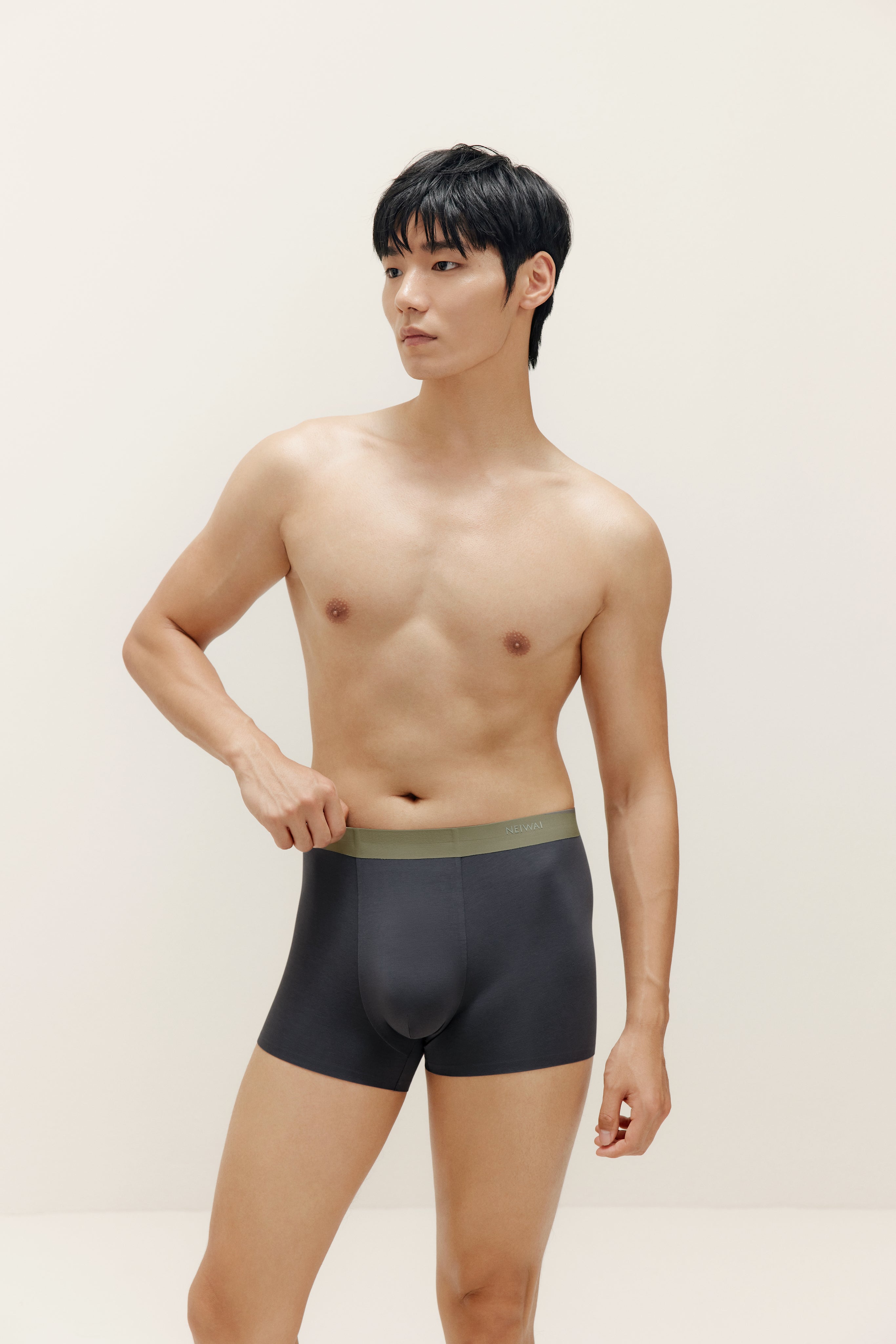 Man wearing navy boxer briefs with olive waistband