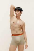 Man wearing beige boxer briefs with orange waistband. Oatmeal color. 
