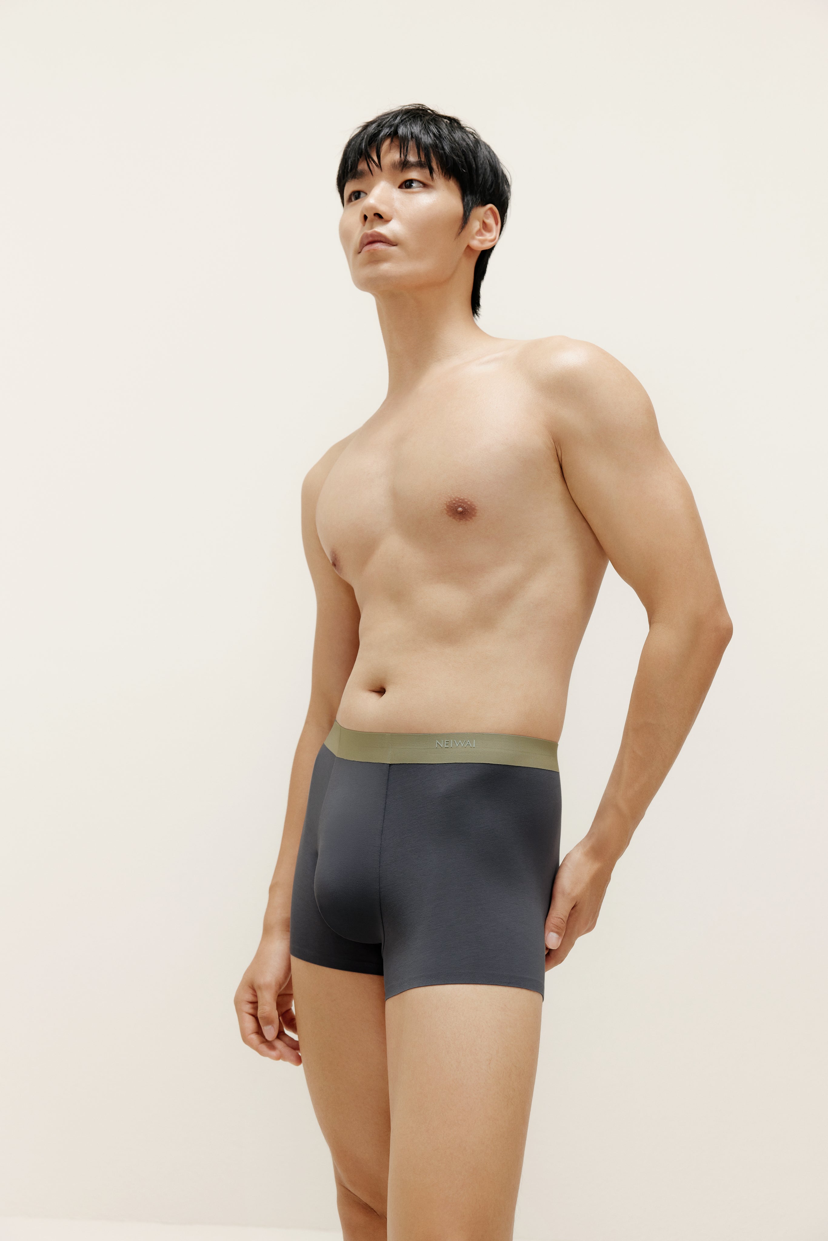 Man wearing navy boxer briefs with olive waistband