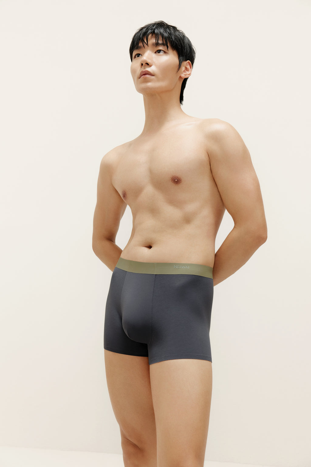 Man wearing navy boxer briefs with olive waistband. Steel Blue color. 