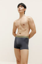 Man wearing navy boxer briefs with olive waistband. Steel Blue color. 