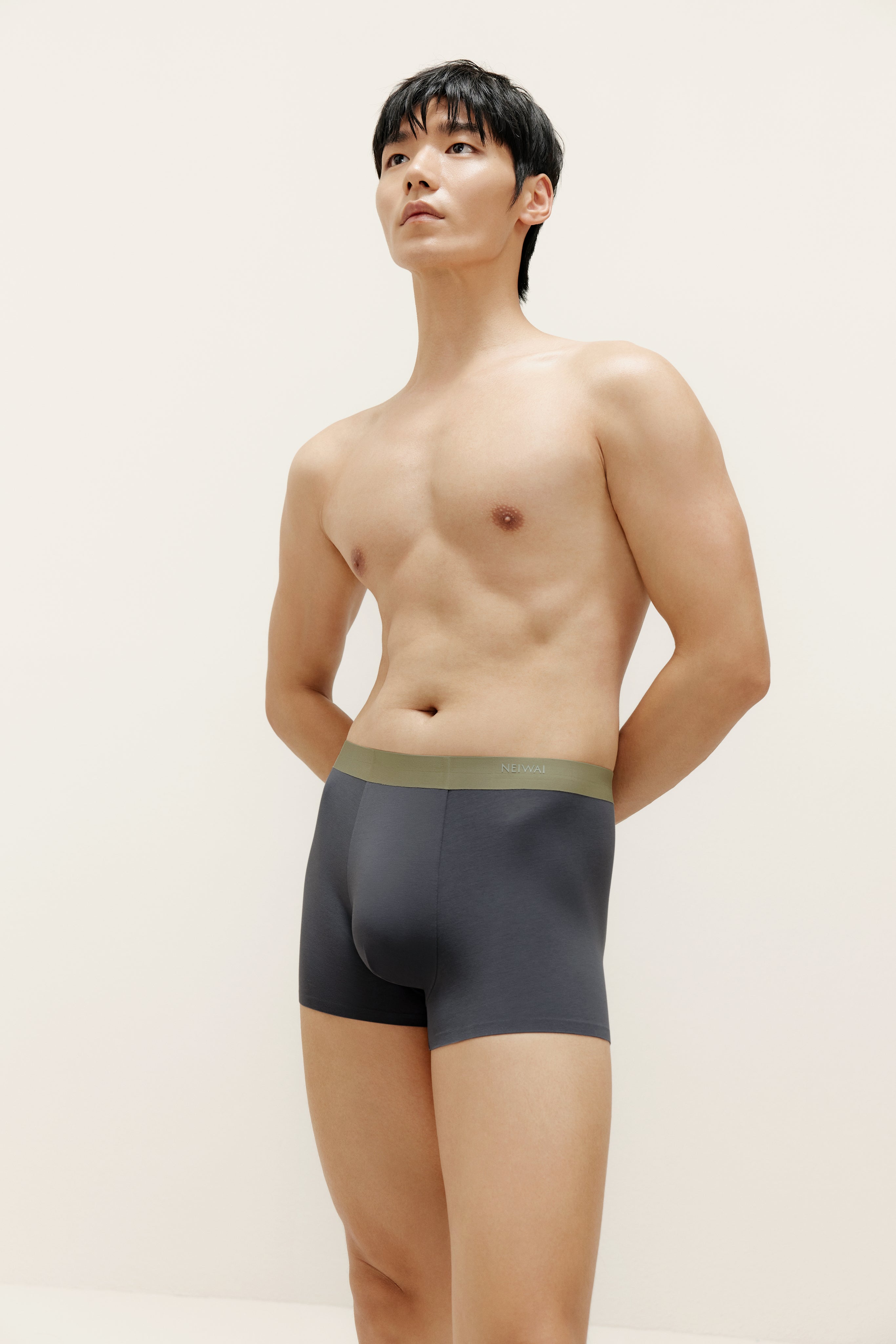 Man wearing navy boxer briefs with olive waistband