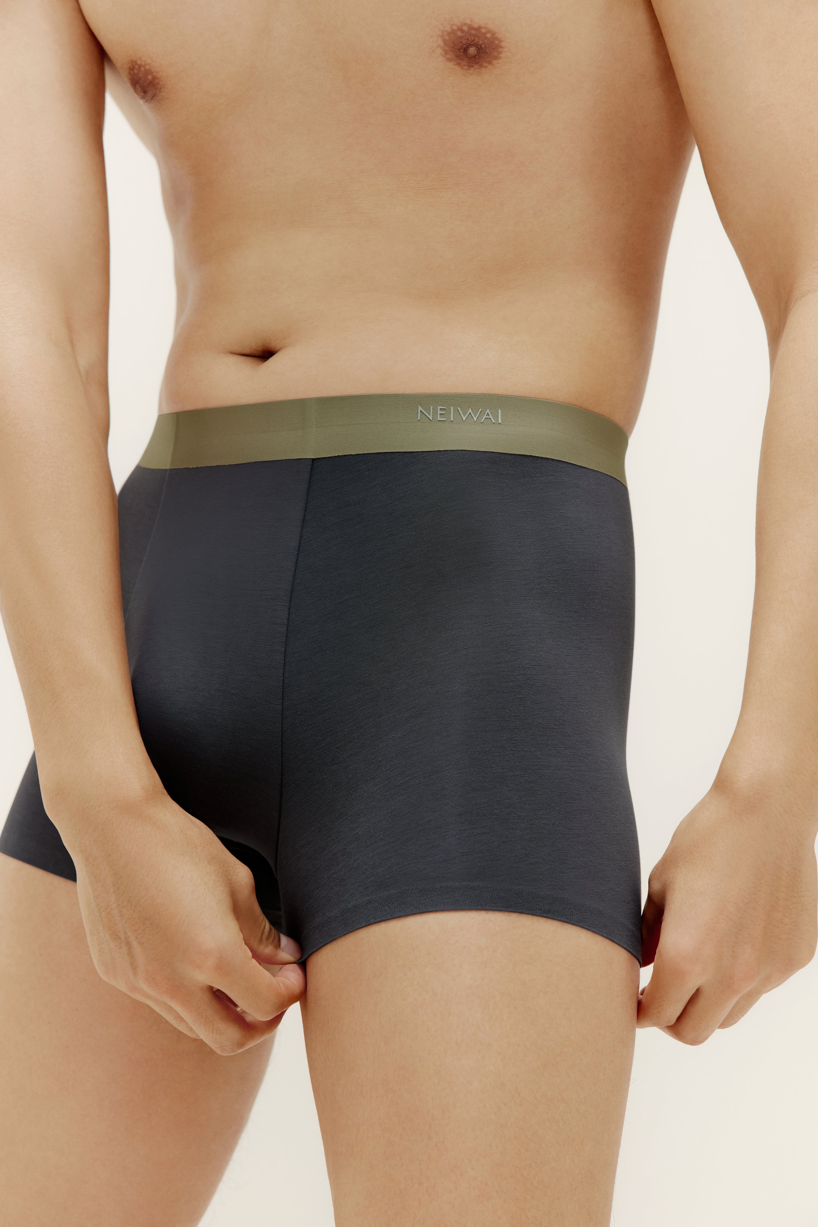 Closeup of man wearing navy boxer briefs with olive waistband