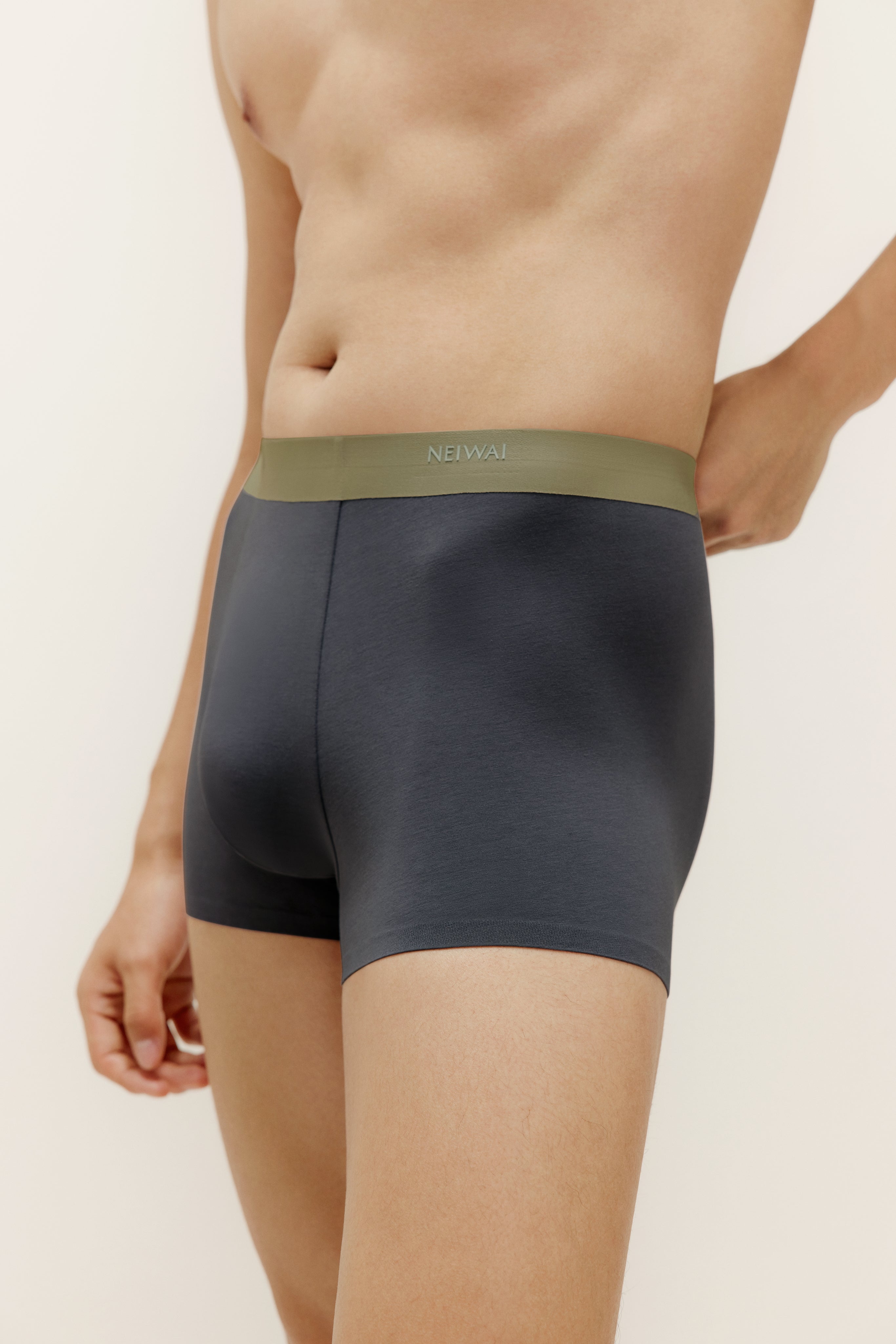 Closeup of man wearing navy boxer briefs with olive waistband