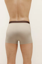 Back of man wearing tan boxer briefs with brown waistband. Light Heather color. 