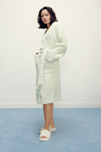 woman wearing a light green fleece robe