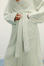 detail shot of woman tie the light green robe