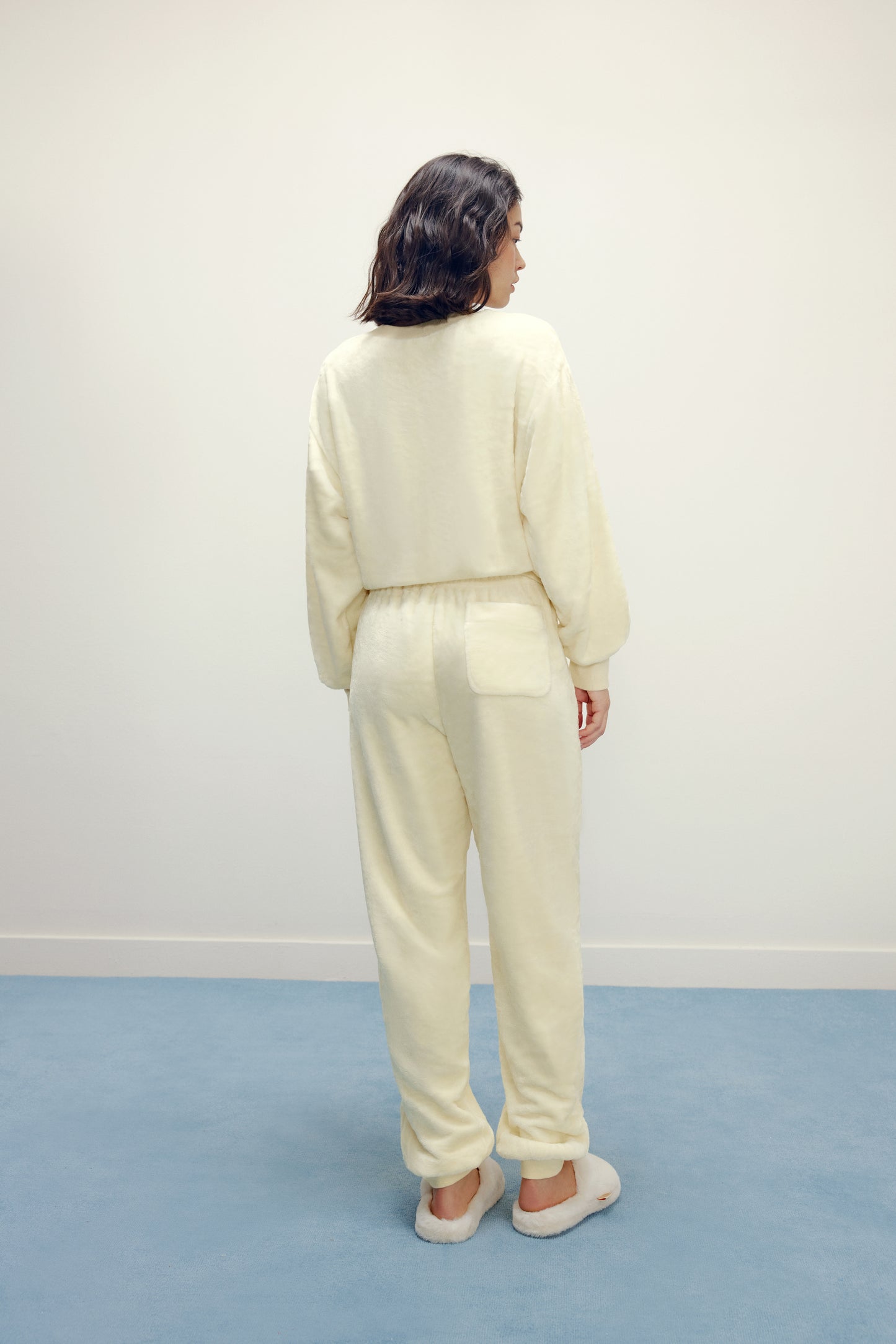 back of woman in cream fleece pajama set