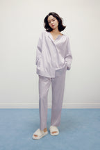 a woman wearing a purple pajama sets and white slippers