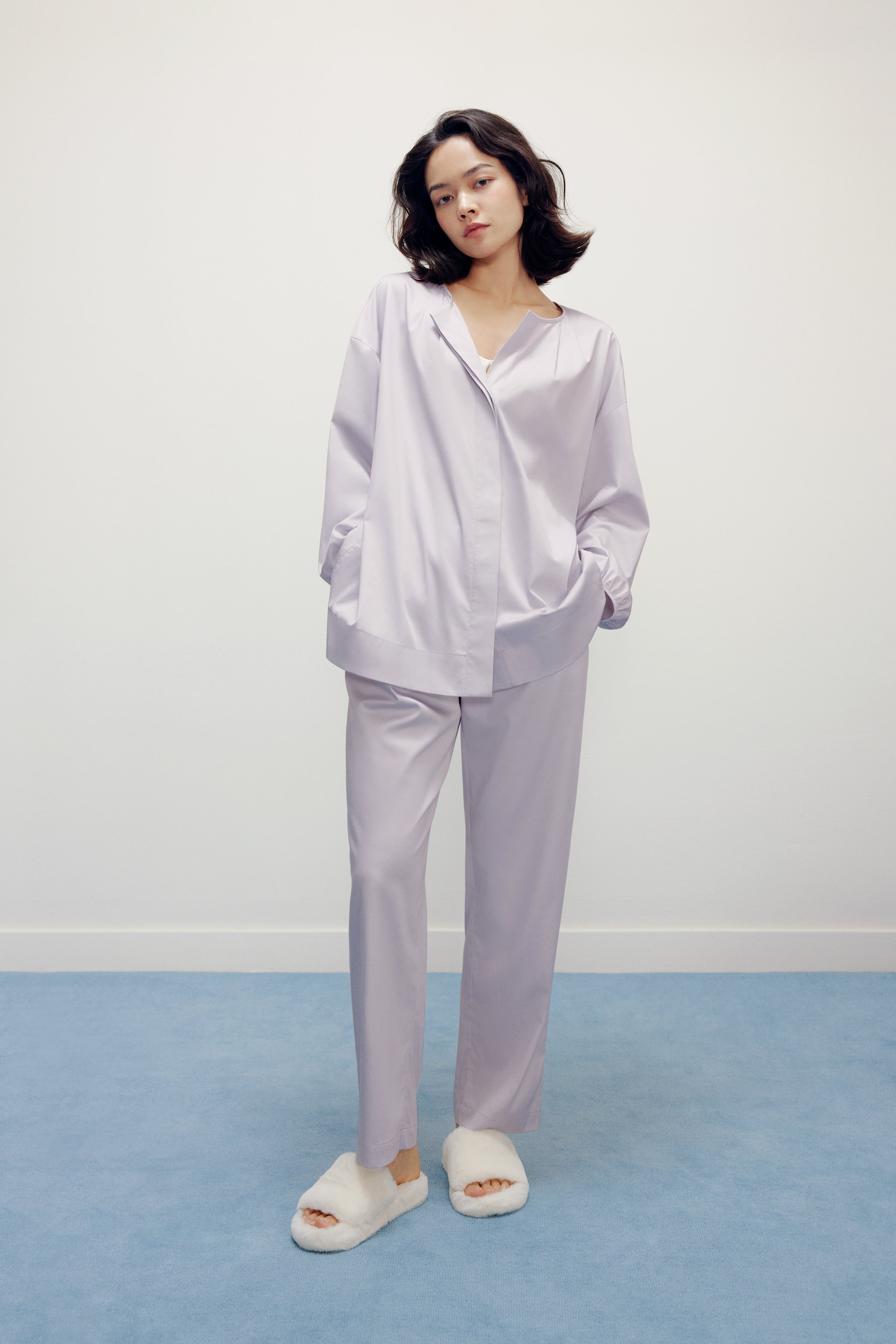 a woman wearing a purple pajama sets and white slippers
