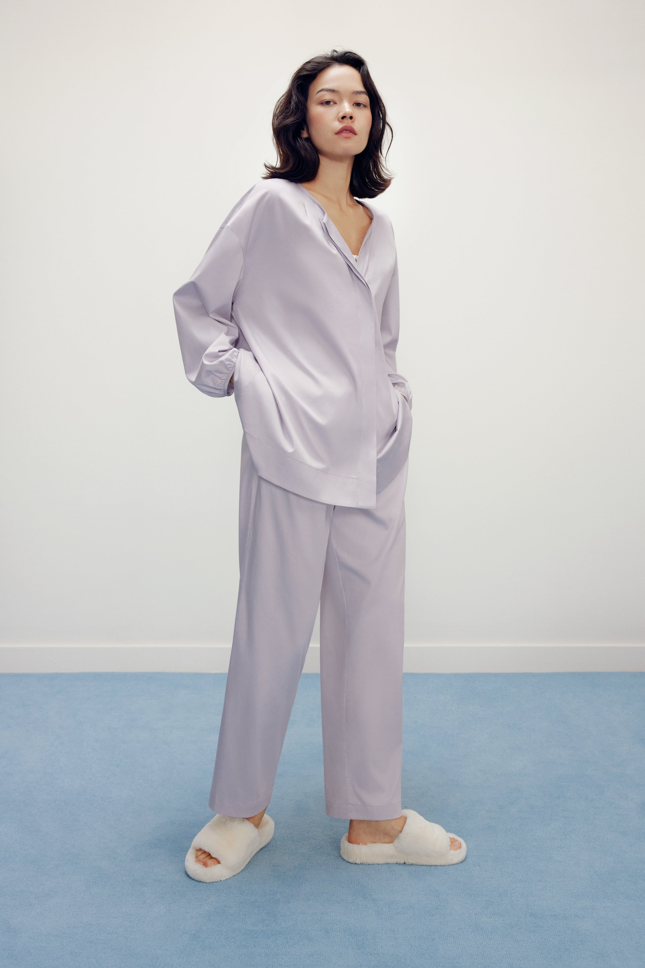 a woman wearing a purple pajama sets and white slippers